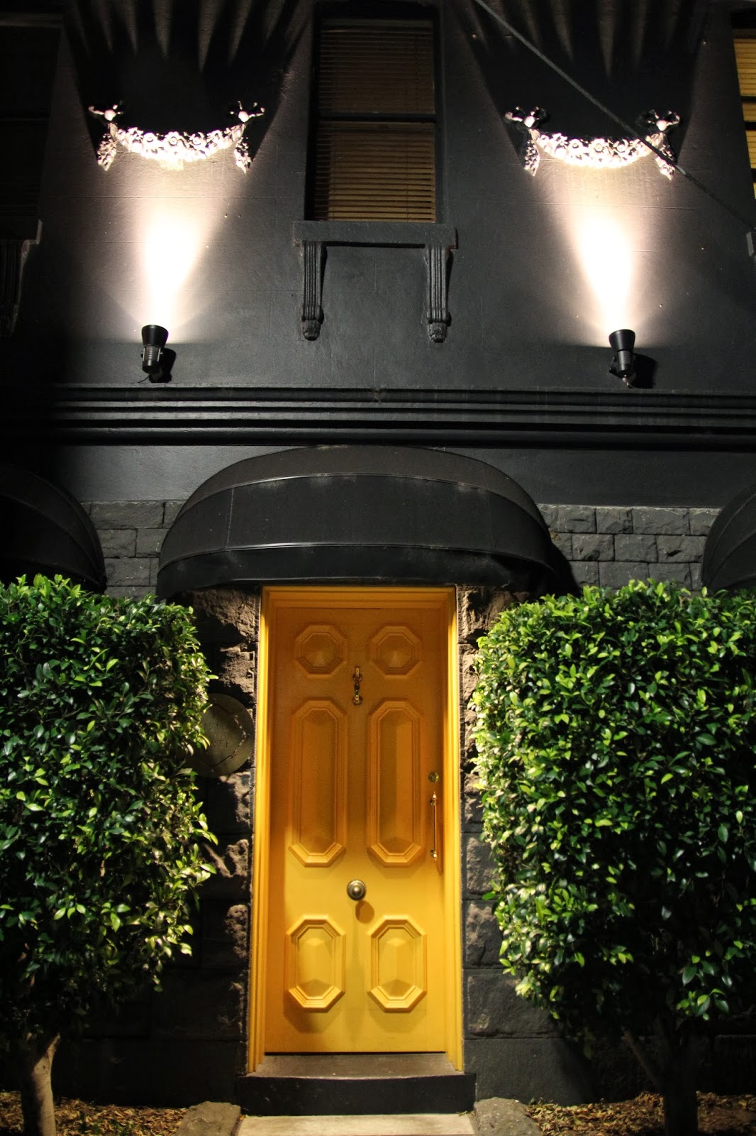 A building at night with a yellow door 