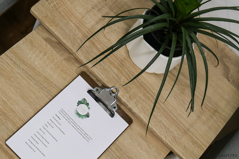 A form attached to a clip board sitting next to a plant on a wooden table