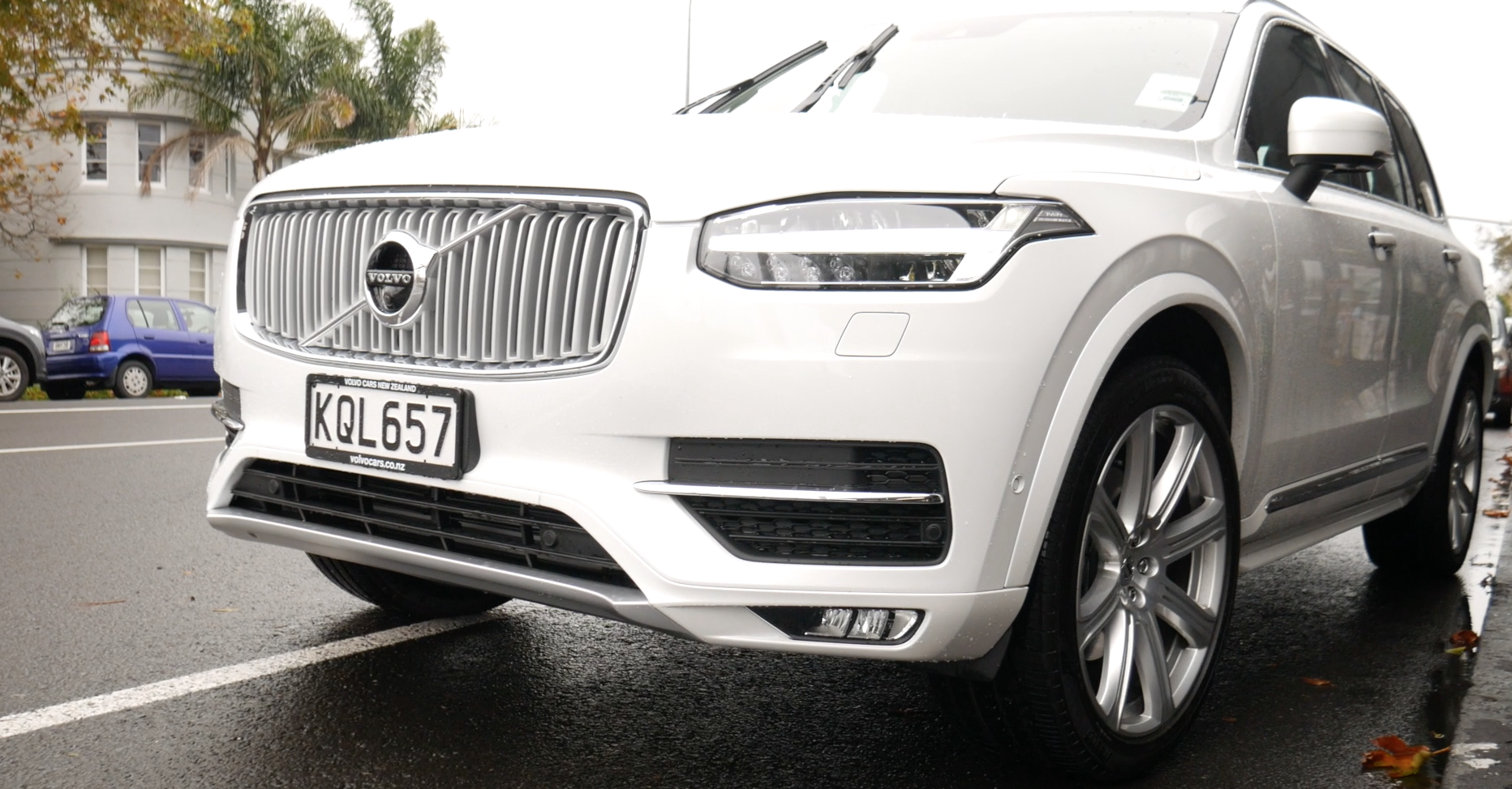 The front of a white Volvo showing the grill and front tyres