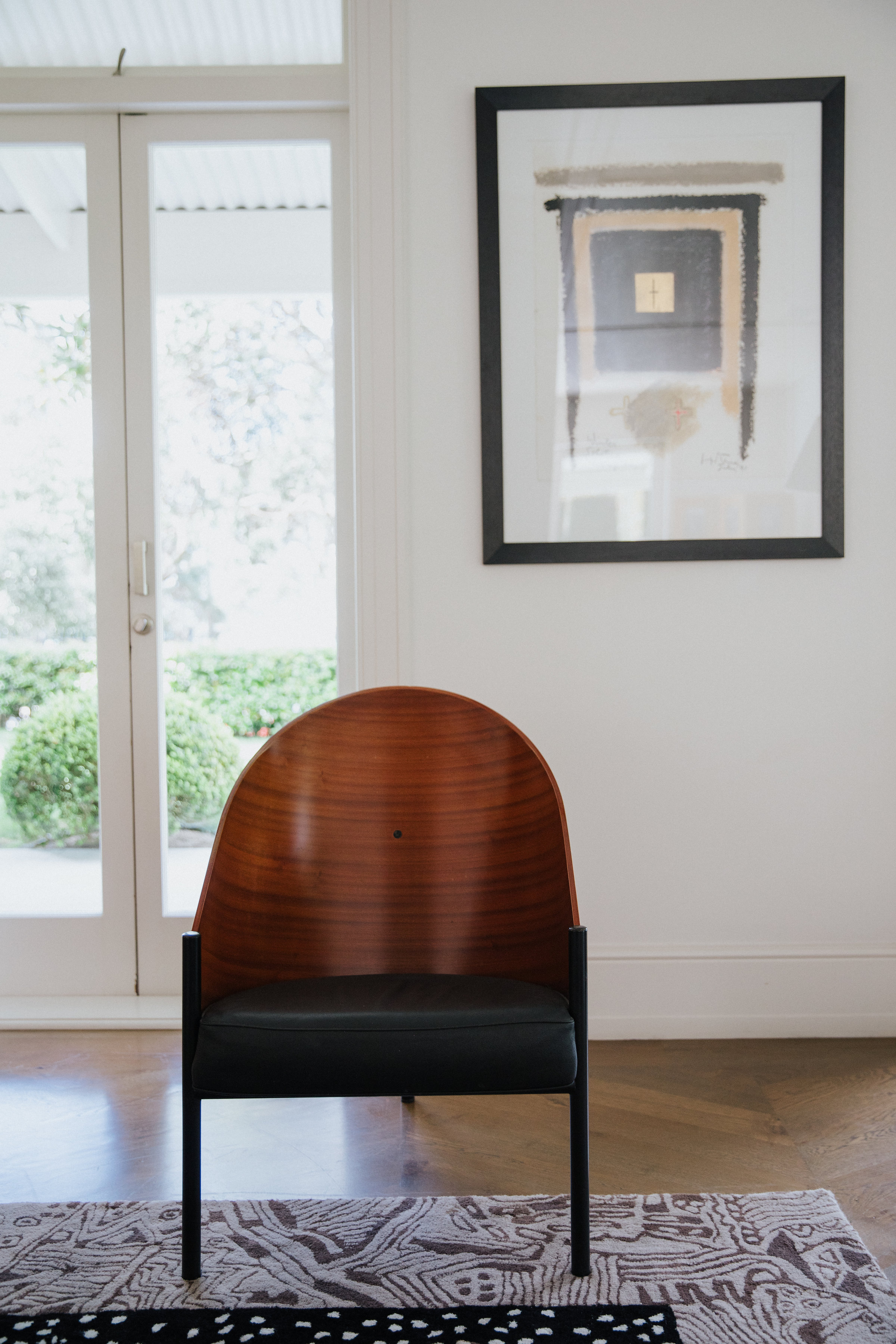 Chair in front of white wall and artwork 