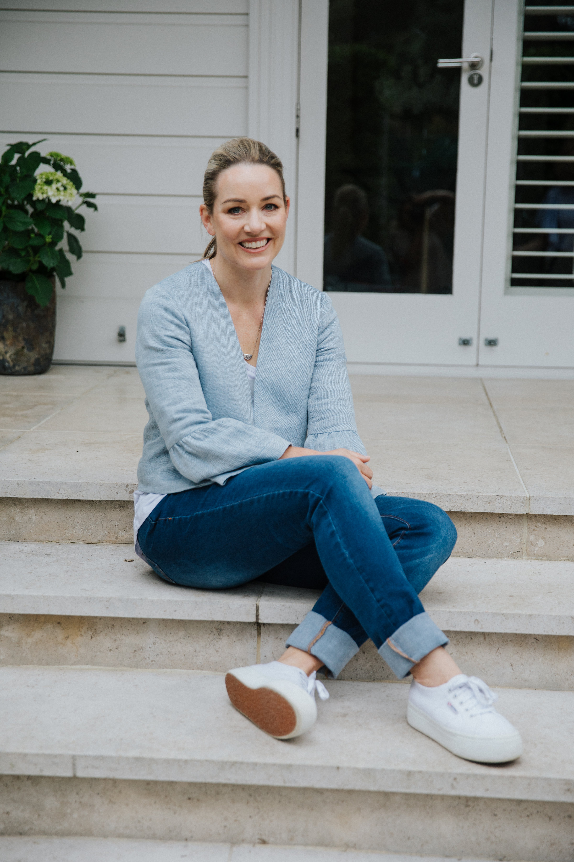 Woman in blue jeans sitting on steps