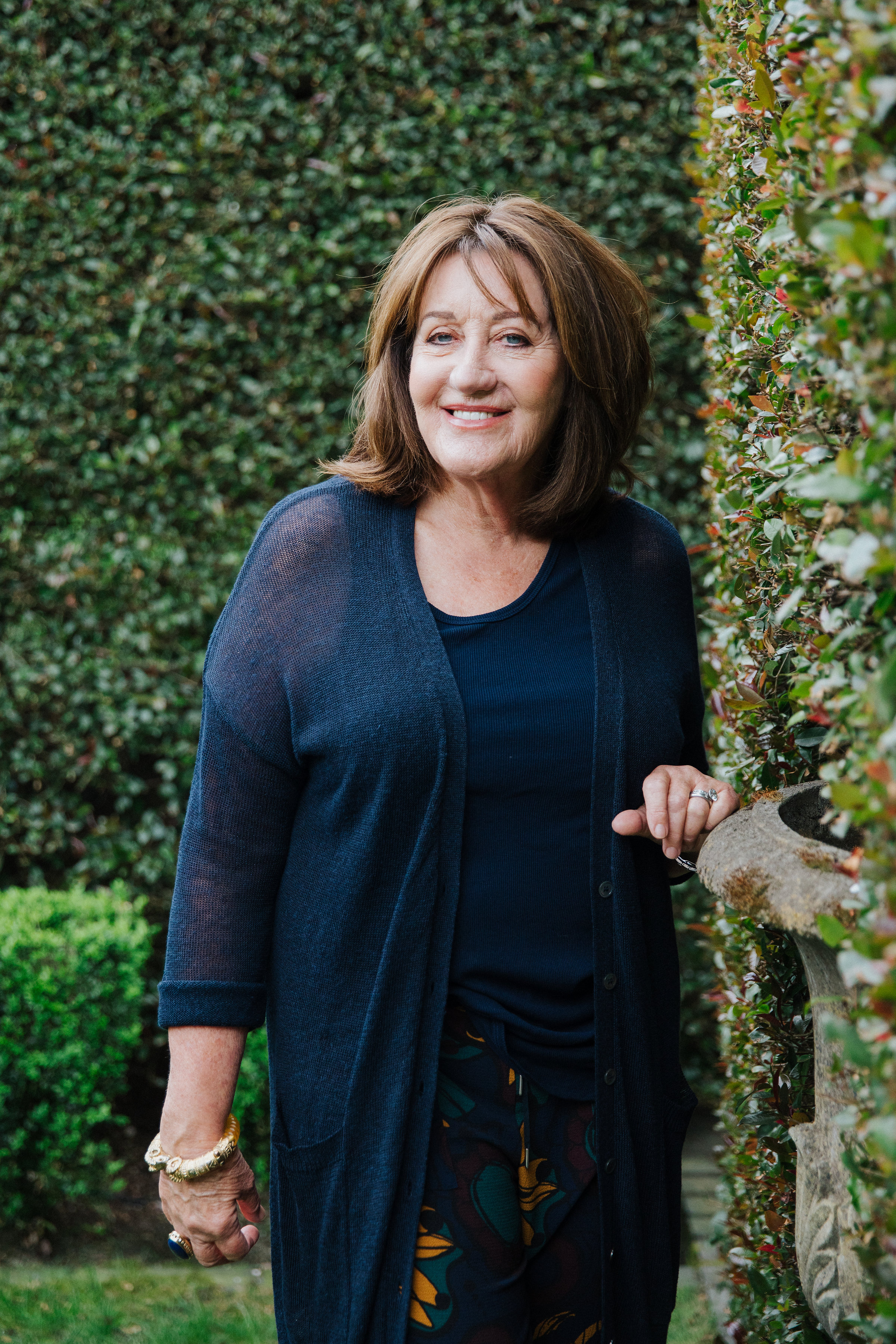 Woman standing next to hedge