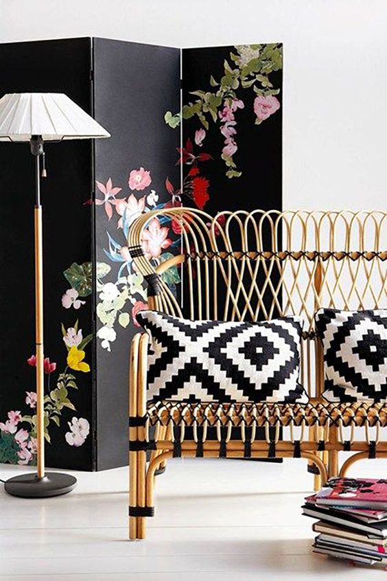 black and white pillows in geometric pattern on cane seat in black and white room