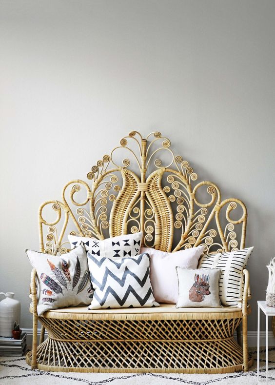 Patterned can chair with pillows standing against white wall