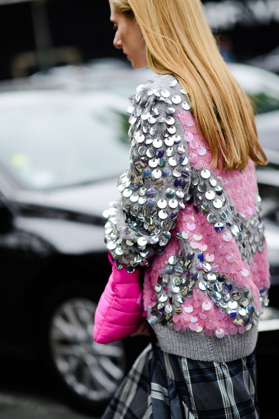 blond hair model wearing sequin seethrough sweater holding pink clutch