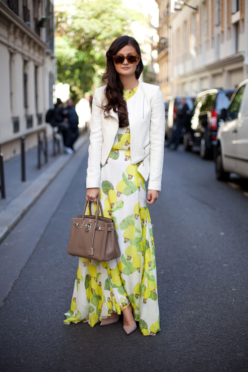 Woman in floral yellow and green dress and white jacket
