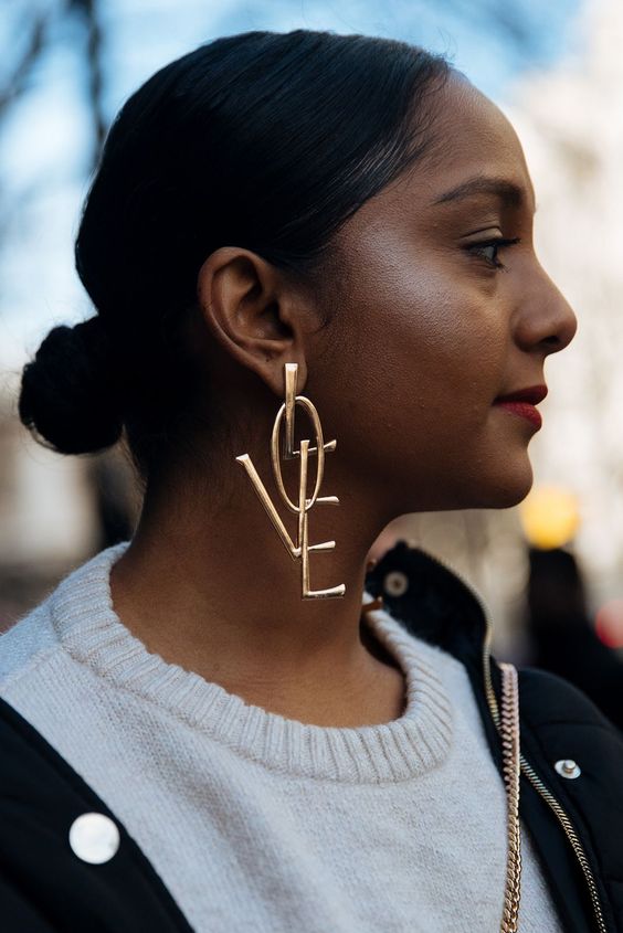 Side view of woman with low bun and big gold earings