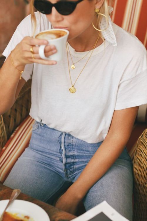 woman in blue jeans and white t-shirt drinking water