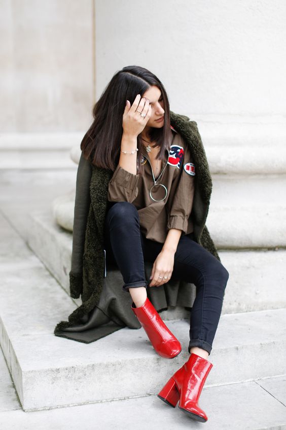 Woman in black outfit and red boots sitting on a step