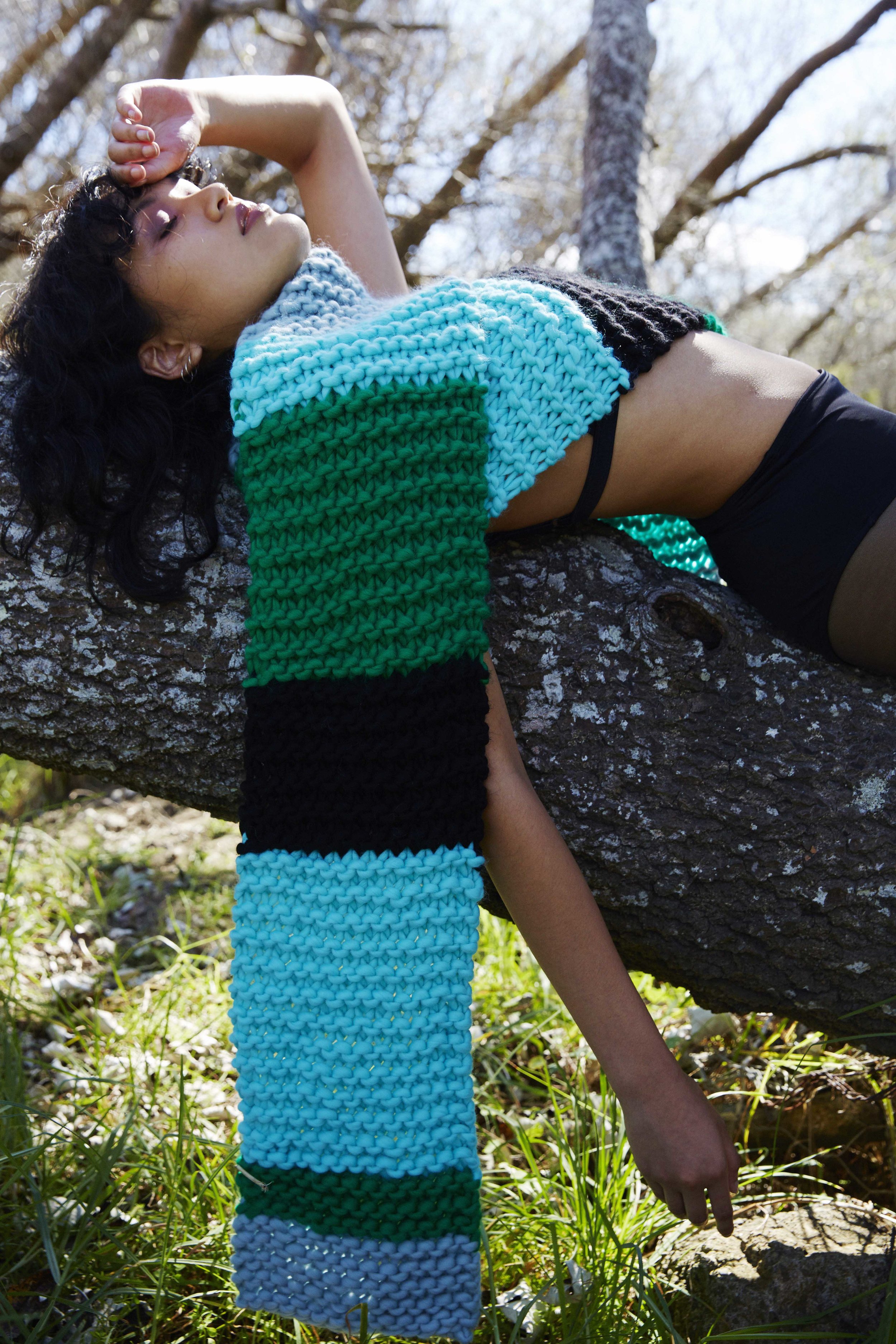 Woman in long black boots and colourful big scarf in the forest