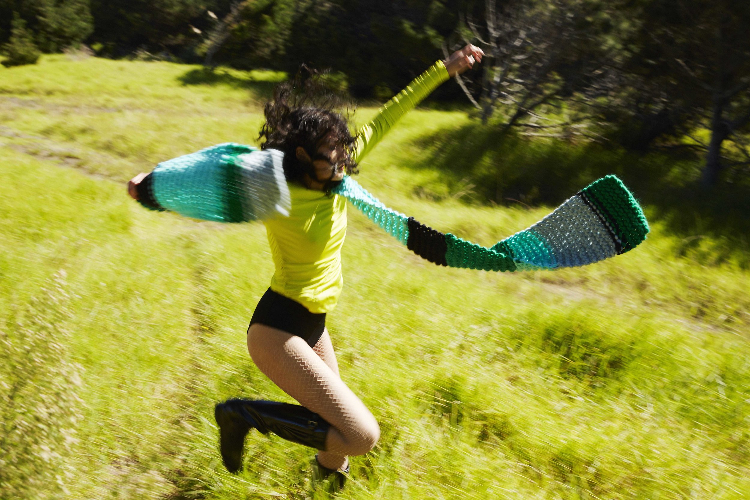 Woman in long black boots and colourful big scarf in the forest