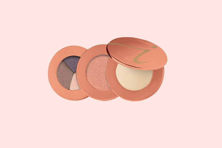 Three Jane Iredale mineral makeup shades layered against a light pink background
