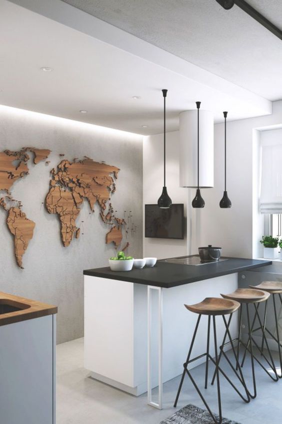 Modern kitchen with black table top and wooden artwork of world map on wall