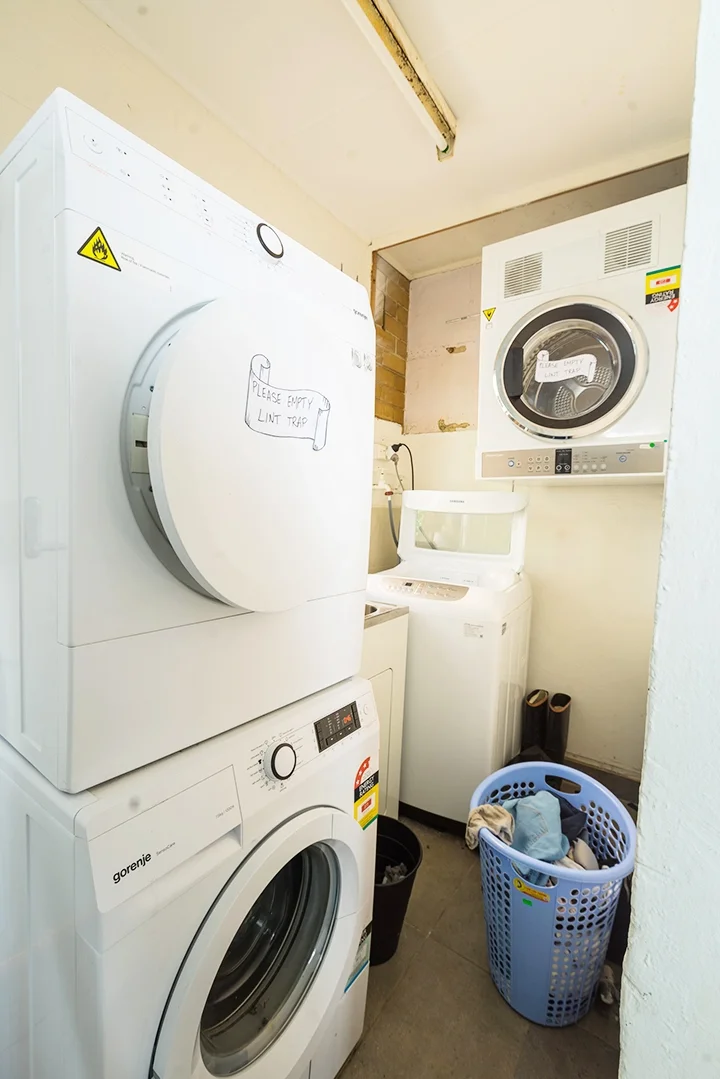  Shared laundry with 2 washers and 2 dryers and sink area 
