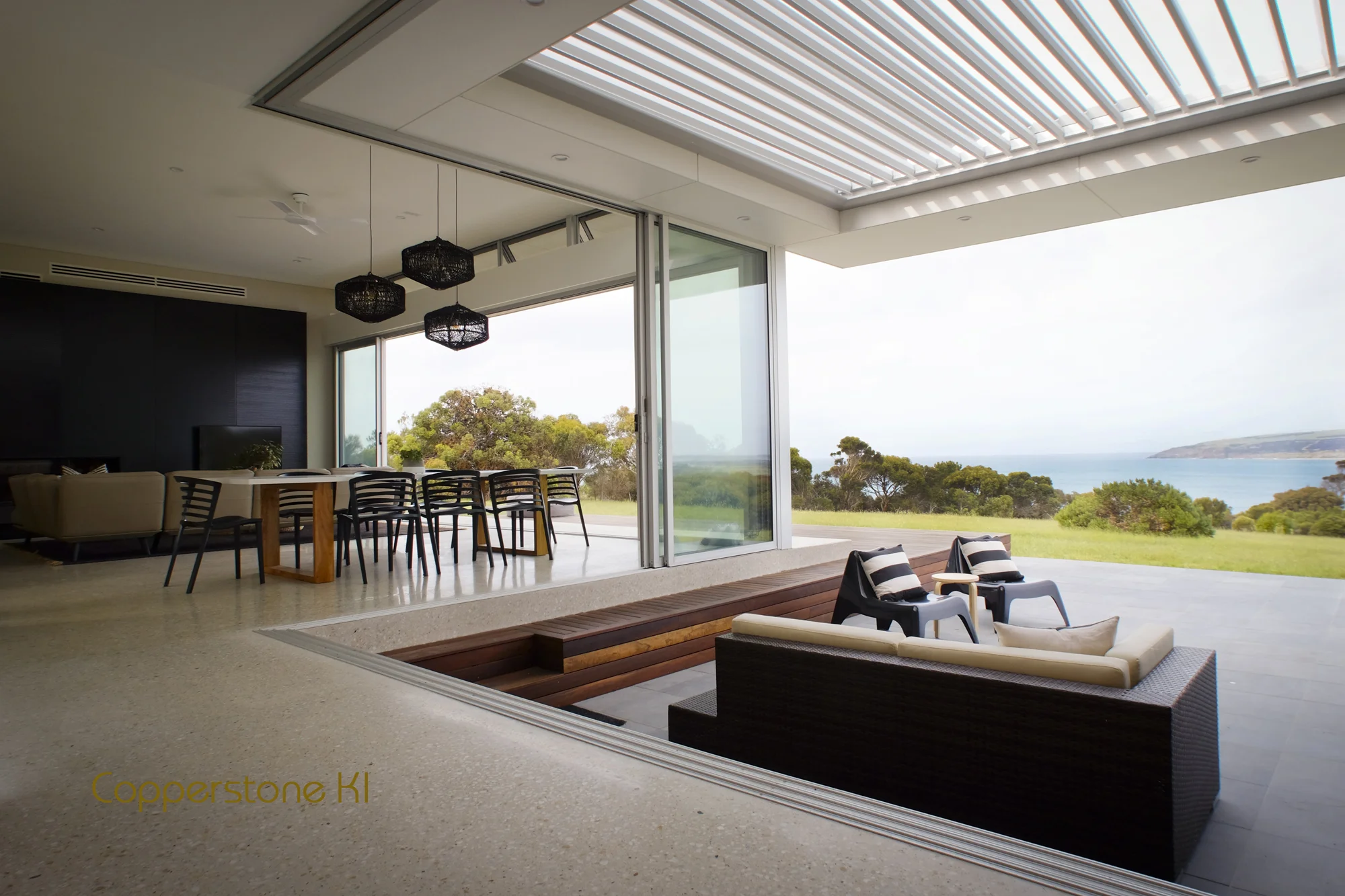 Sunken courtyard/outdoor entertaining area, extends to main deck. Roof louvres control environment. Fully opened main windows, transition between living spaces.