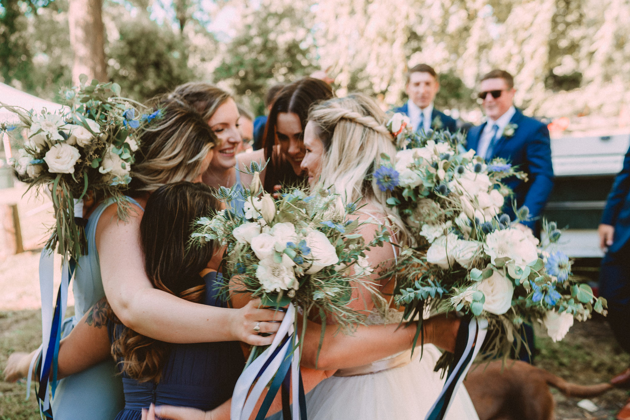 Post Ceremony Bride Bridesmaid hug florals bouquets