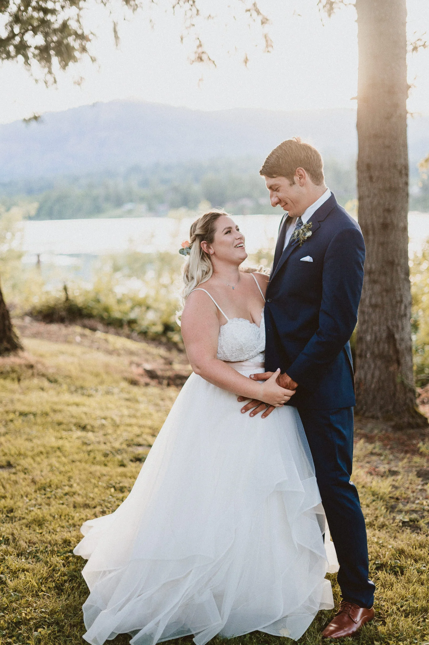 Sunset backlit portrait bride groom blue suit vertical portrait mode
