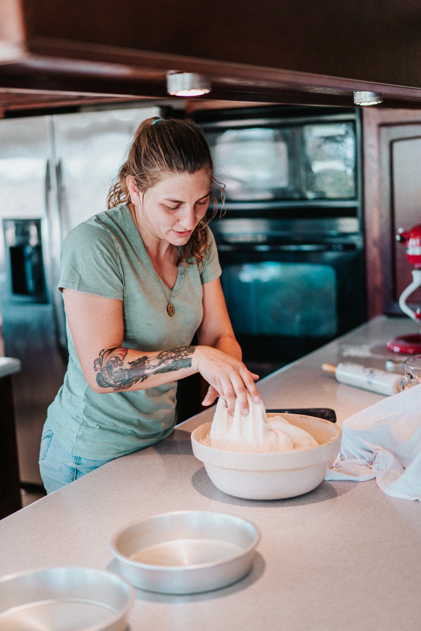 A homesteader kneads her dough.