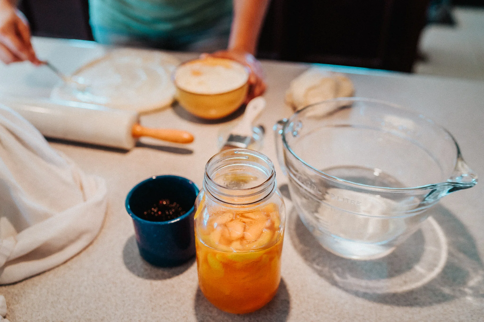 Bowl of water, canned peaches and dough.