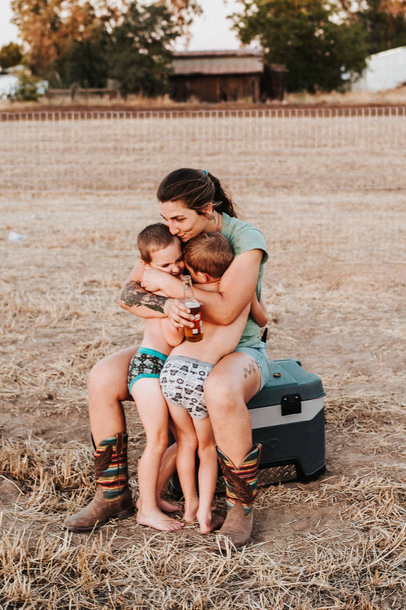 Mother cuddles her two sons.