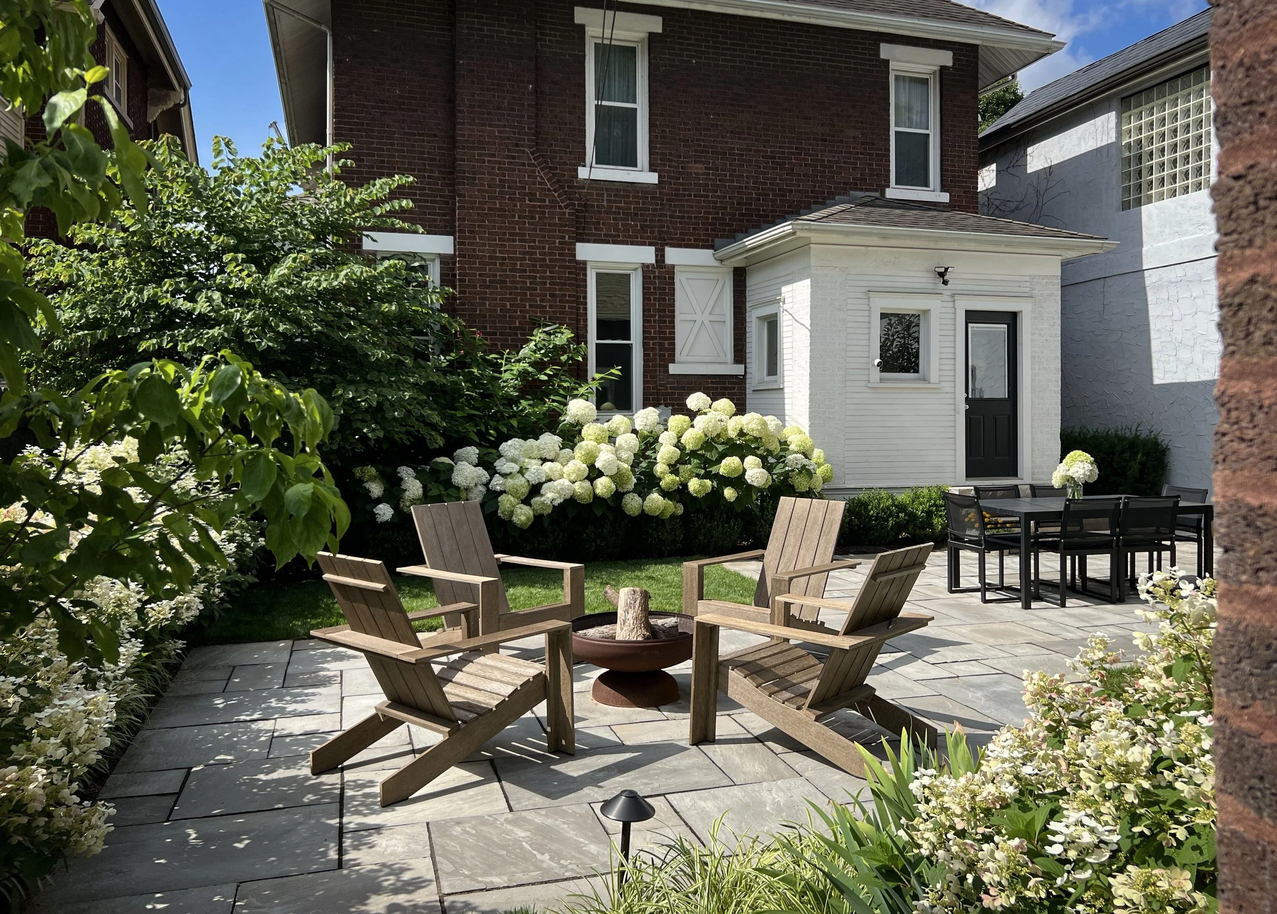 backyard living space with bluestone and firepit and hydrangea.jpg