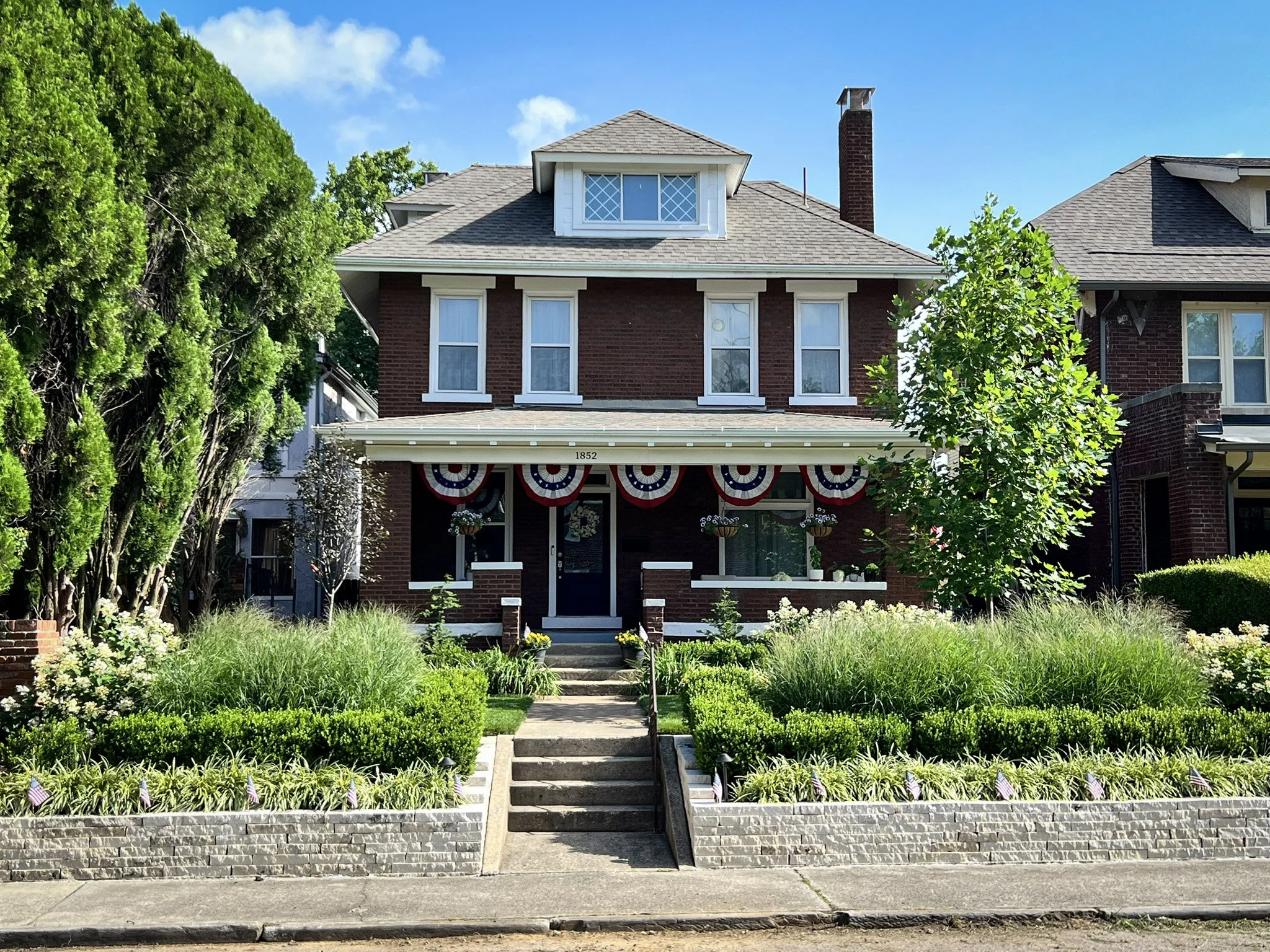 Front yard landscape with switchgrass boxwood and limestone wall.jpg