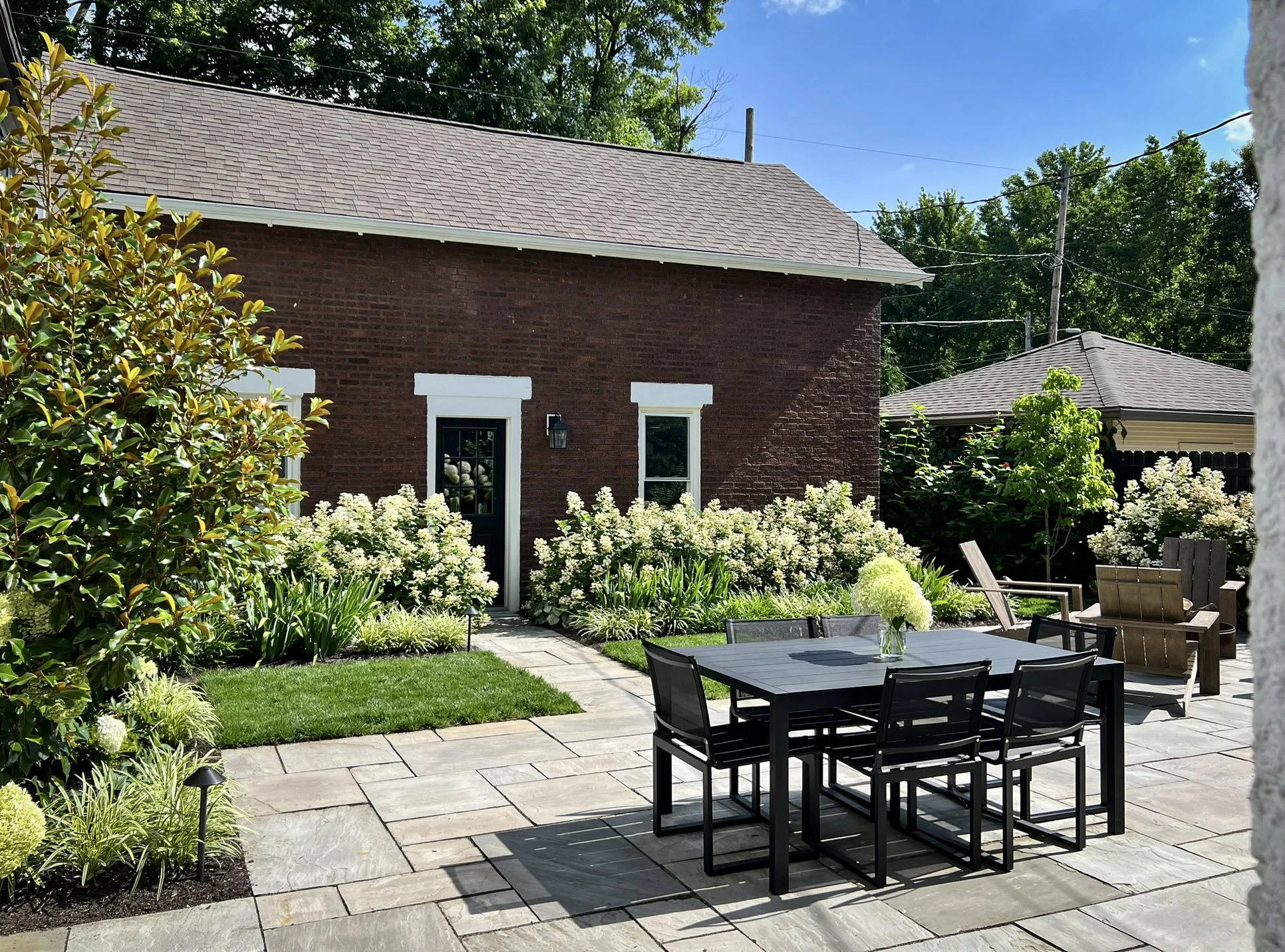 backyard bluestone patio with brick garage.jpg