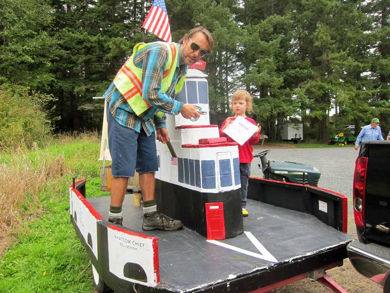 Ferry crewman Tom Phillips helps a little passenger with a huge ferry pass