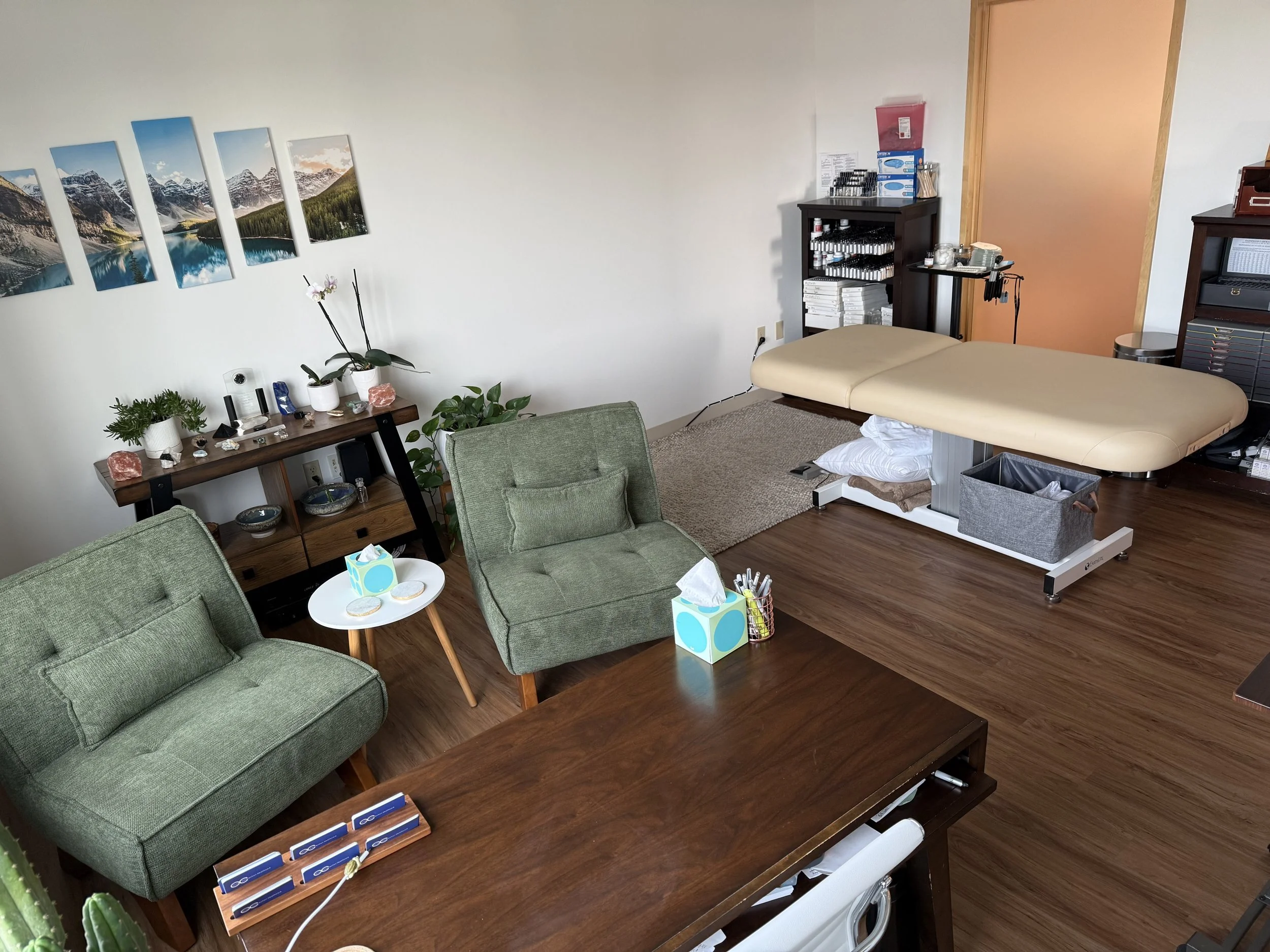 doctor's office with wooden desk, two size inclusive, green chairs, and exam table