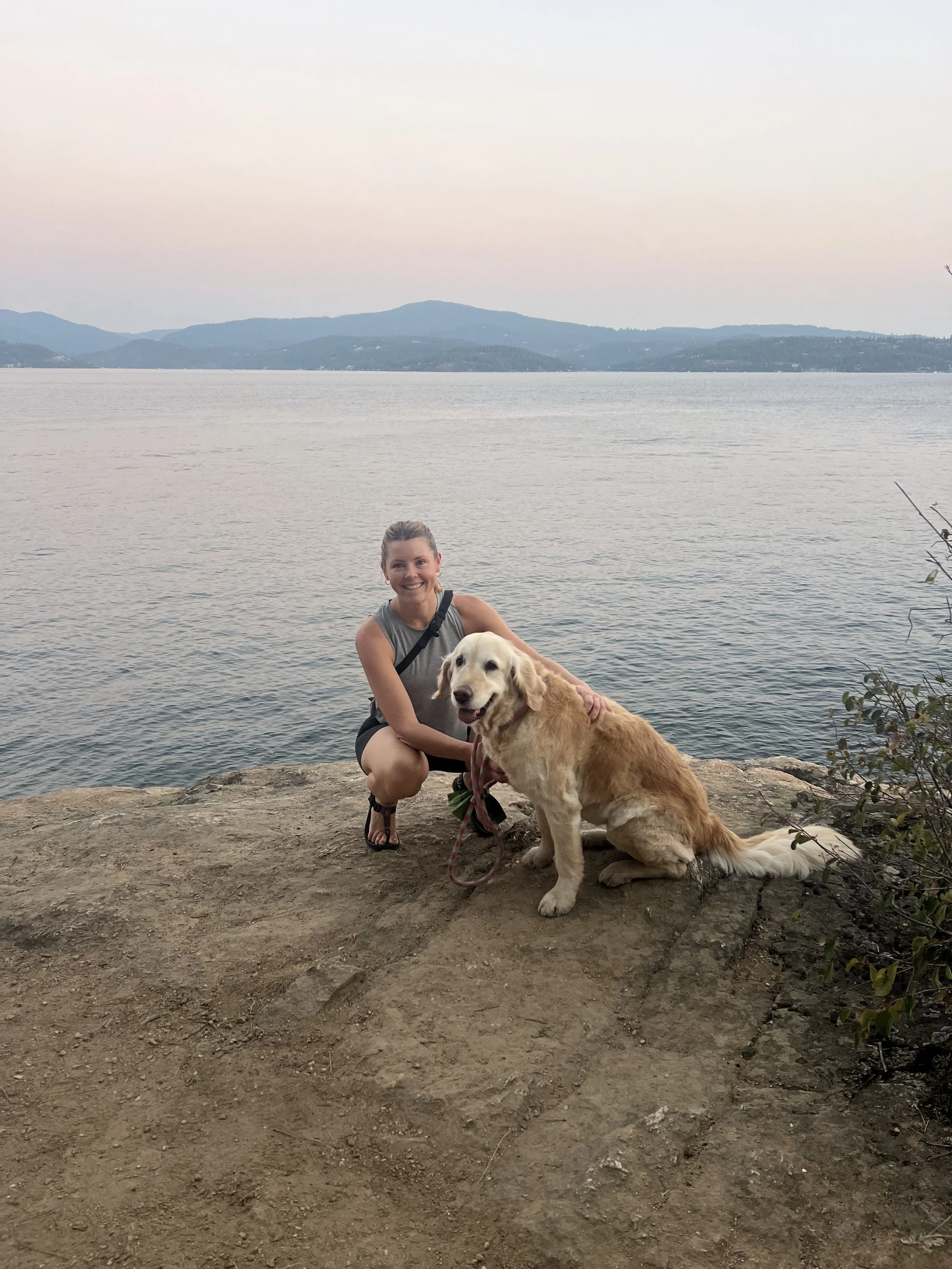 Dr. Alison Hearst adventuring with her dog beside the water.