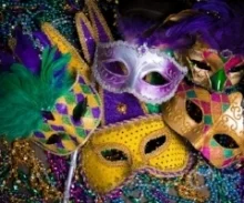 Image shows 5 Mardis Gras** masks over many strings of beads.