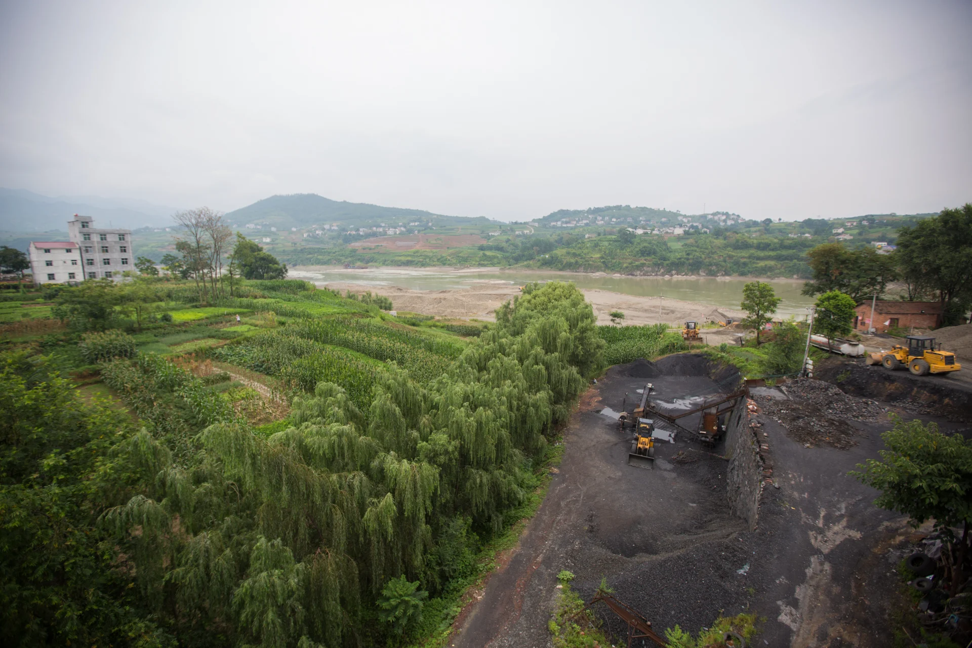  A lone farmer tends fields against the development just beyond the trees in Ankang, China, on July 22, 2015. 
