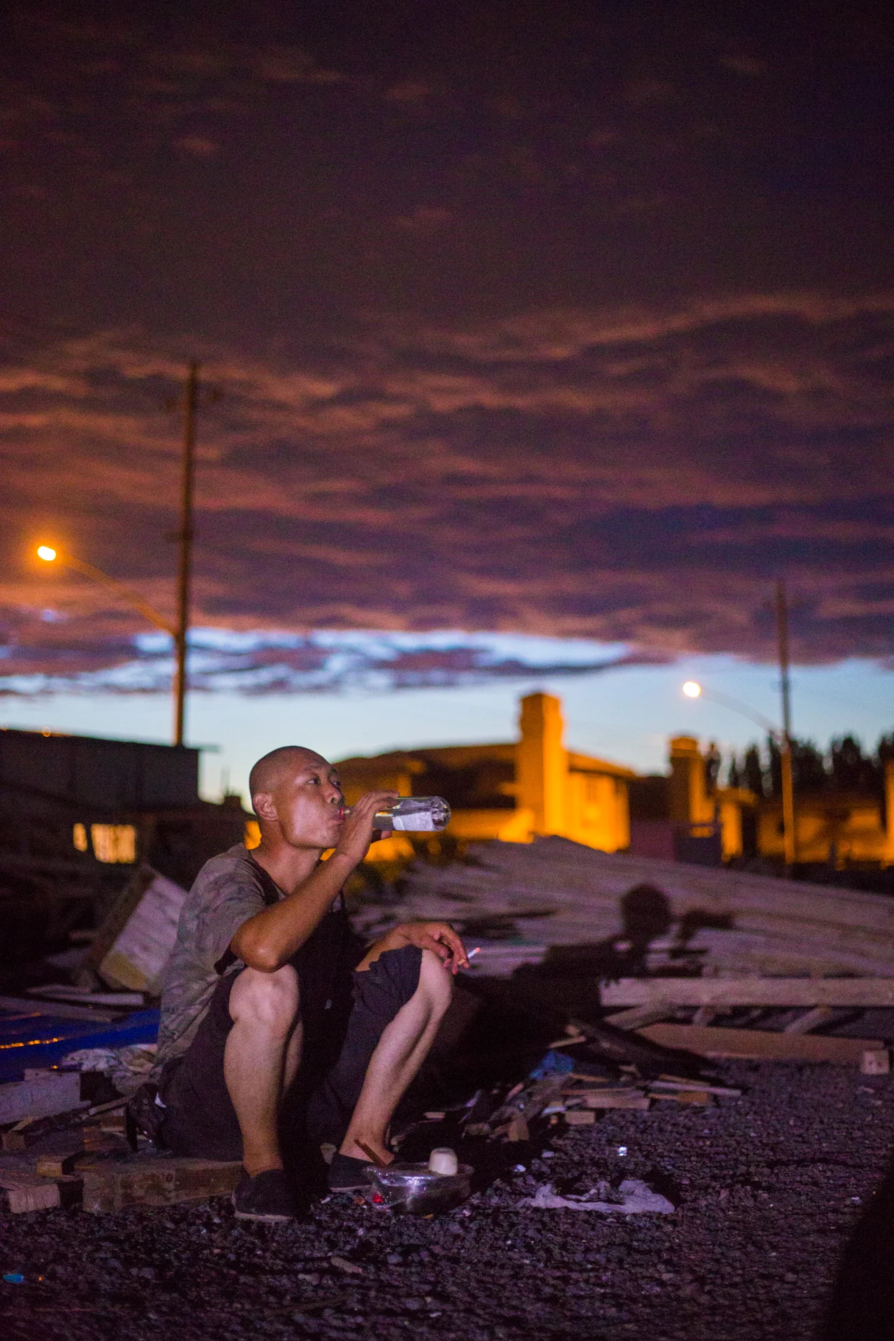  Wang Wen Long finishes dinner at a construction yard on August 3, 2015, in the Chaoyang district of Beijing where he works and comes each night to eat and talk with other workers doing the same. Originally from Hebei with a wife and two children, he