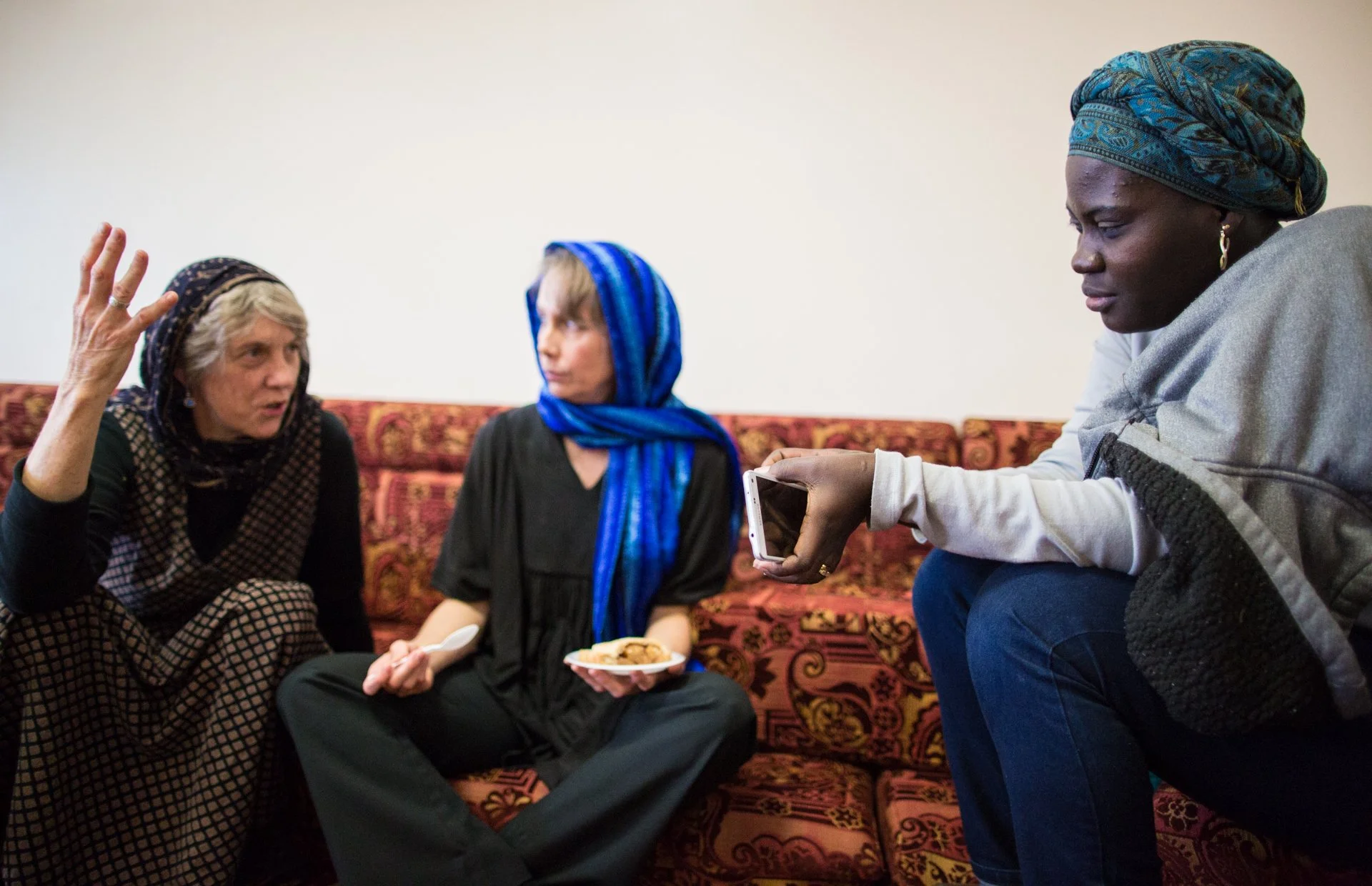  Adetomiwa Akinyemi (right) from Nigera, talks with Trisha Lachman (far left), a local artist whose work will be on exhibit in Athens, and Dr. Kathleen Enger, who works for Global Dialogues. Both Trisha and Kathleen are members of the Quaker communit