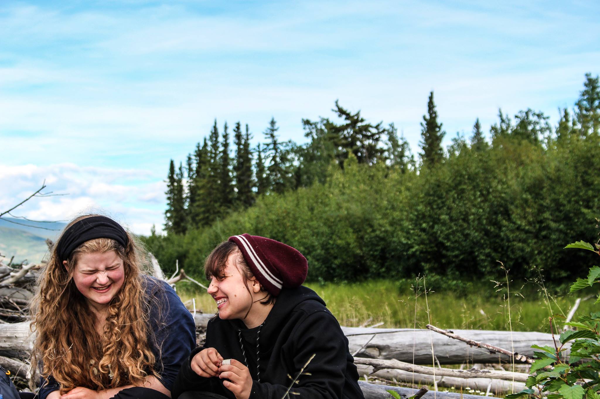  Two girls laughing together beside Yukon River 