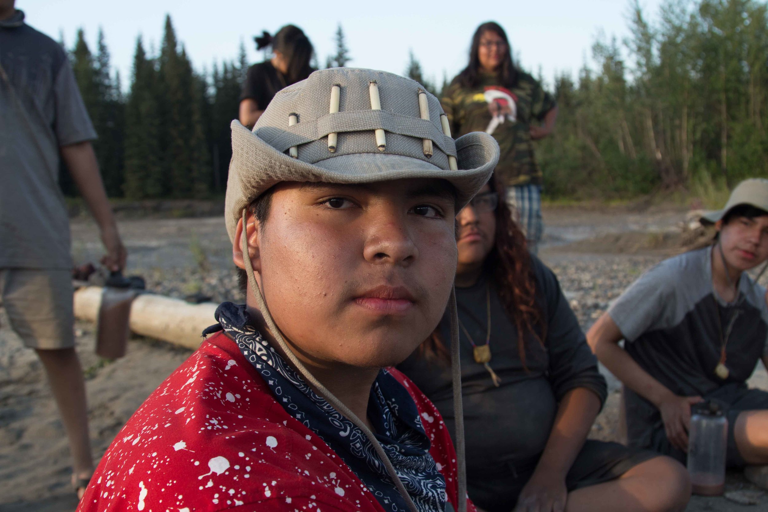  Indigenous boy on shore of Yukon river looking into camera 