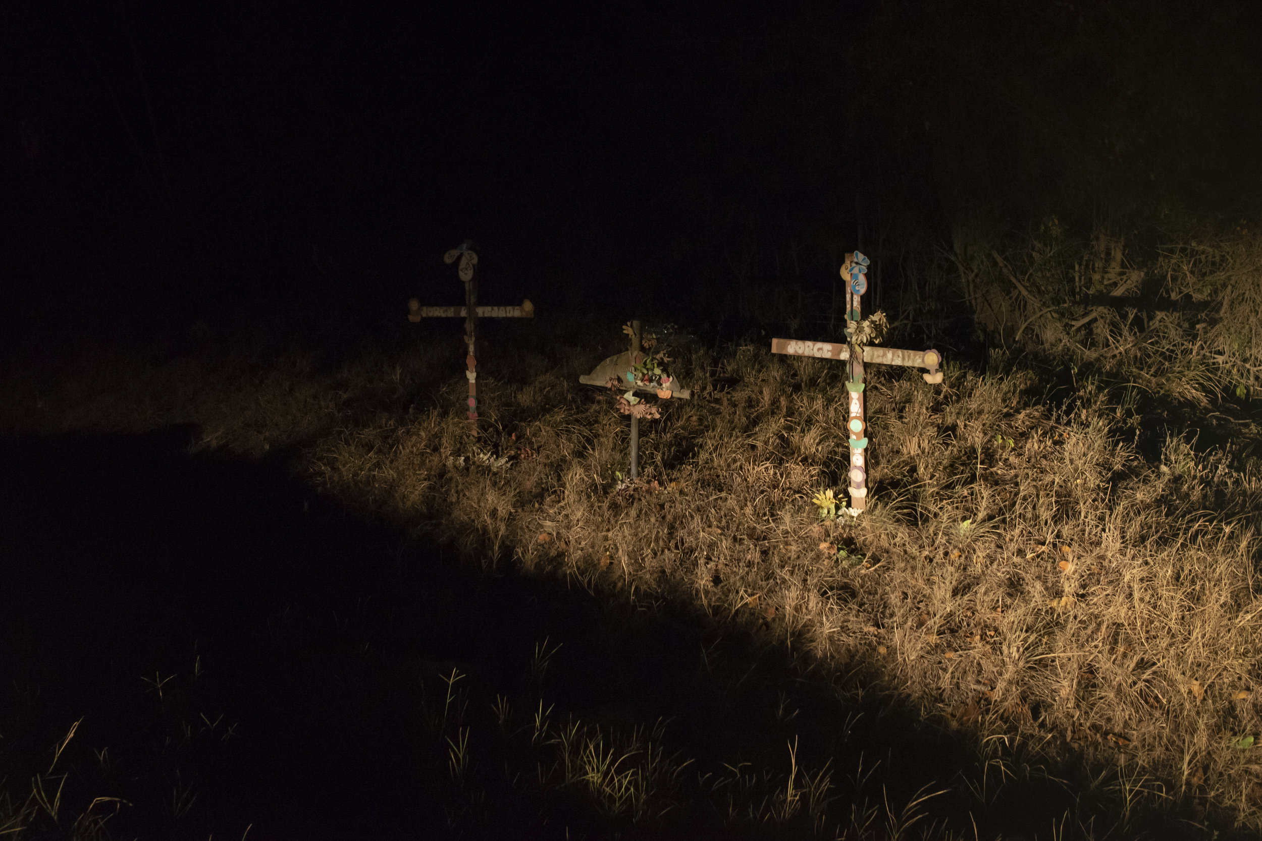  Crosses in a ditch marking the location where three dead bodies were found. San Pedro Sula, Honduras. 