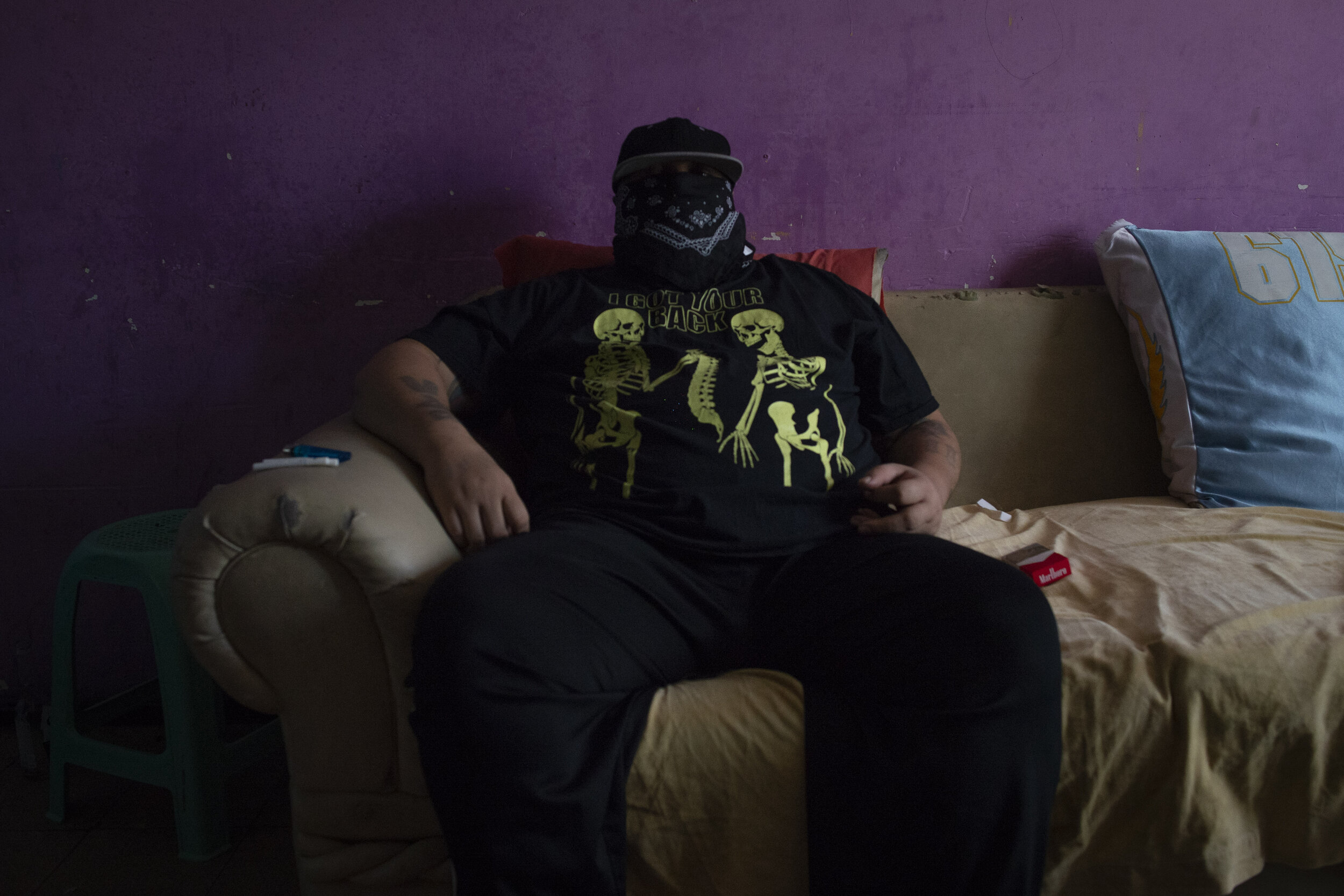  An MS-13 gang leader, known as Marvin 'The Psycho', sits inside his home in San Salvador, El Salvador. High ranking gang members are becoming increasingly more reclusive due to clashes with police. At age 37, he attributes the length of his career t