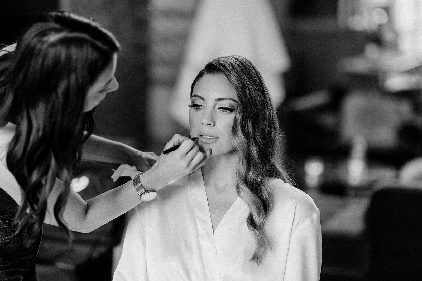 bride getting her makeup done in her robe