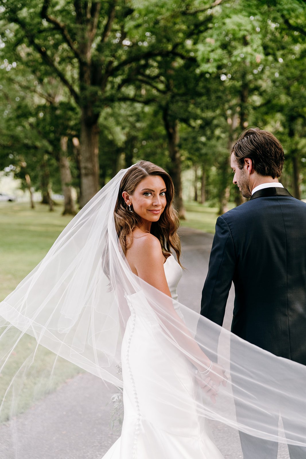 bride and groom walking with veil flowing behind them