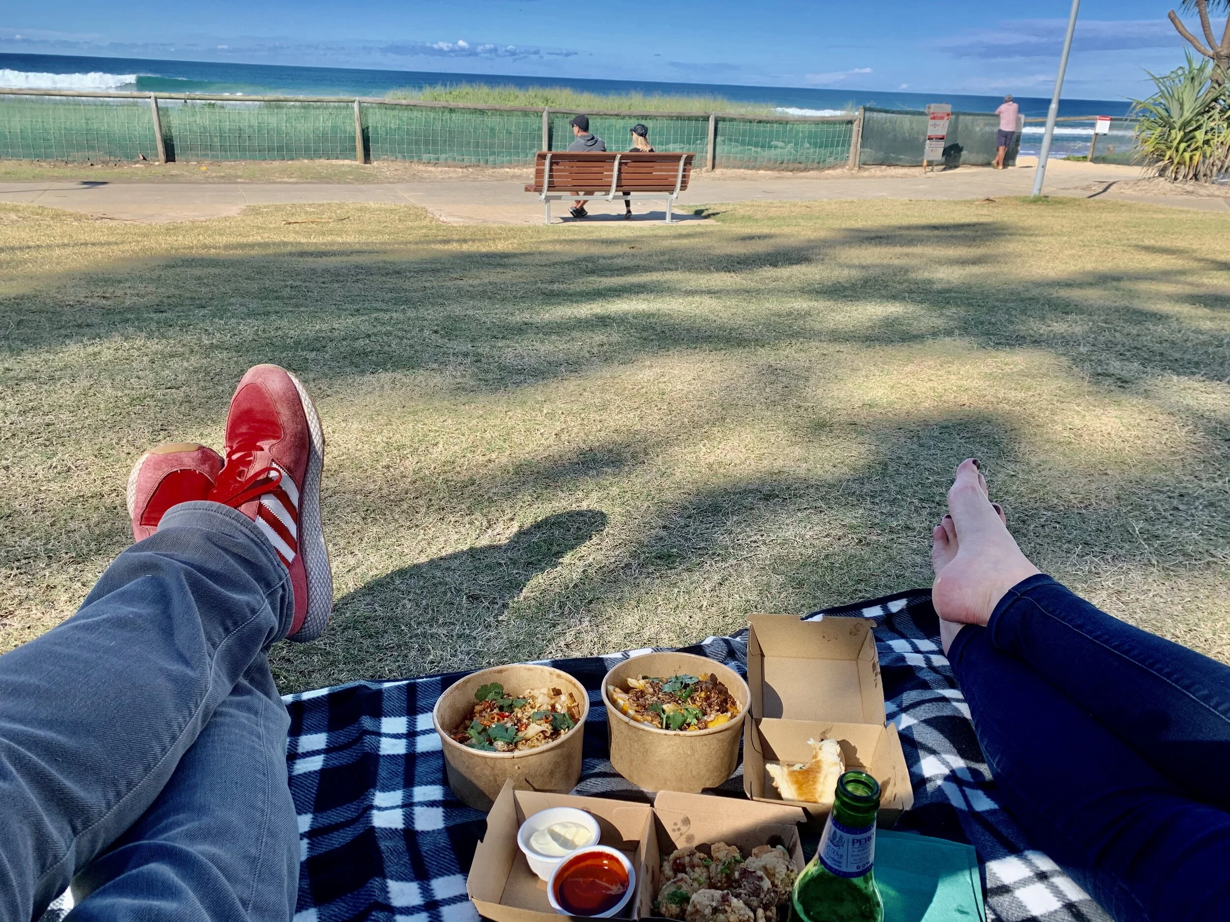 Two people picnic at the beach