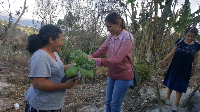 Adria Gamez helping a woman in her vegetable garden