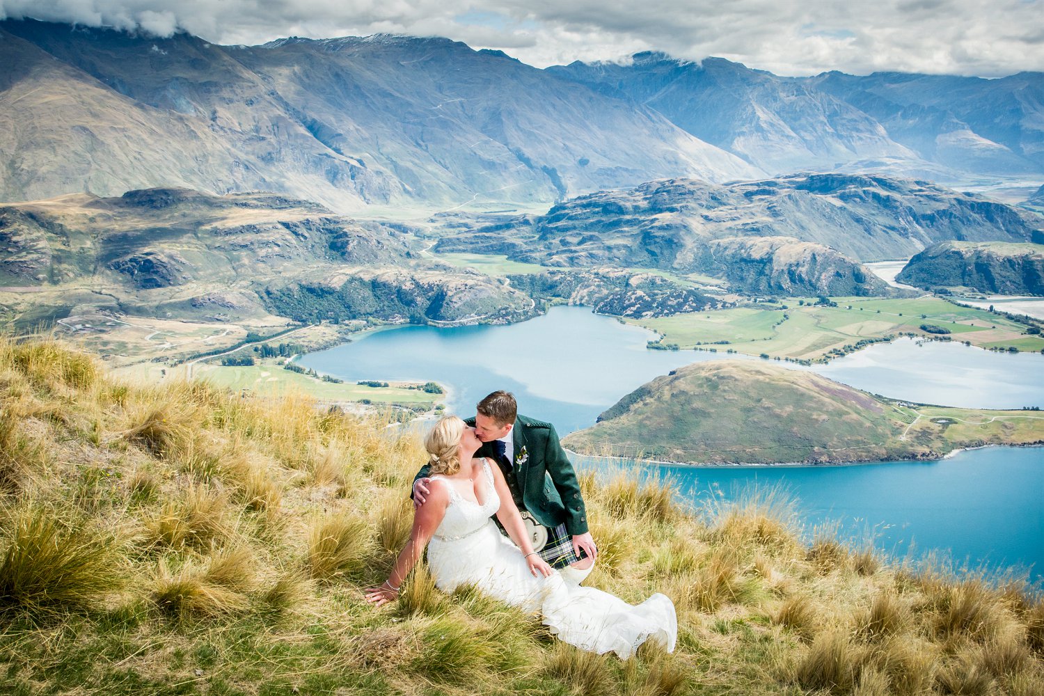 Couple kisses with Lake Wanaka in background
