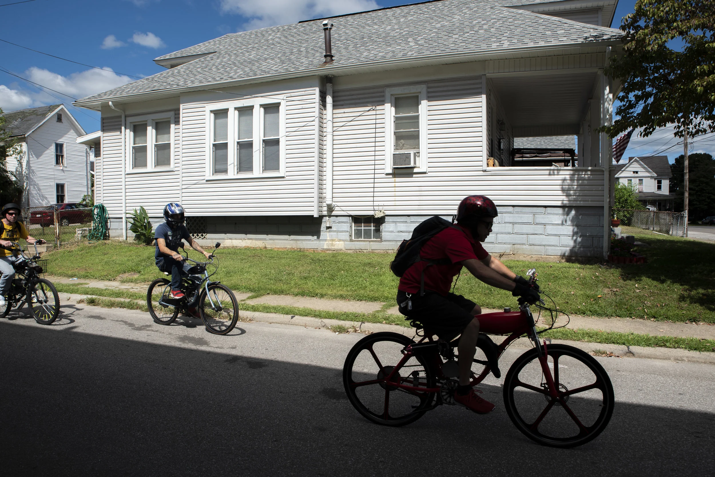 (from left to right) Steve Ramsey, Dale Akers and Rex begin to accelerate their motorized bicycles to prepare for a ride around the City of Parkersburg.