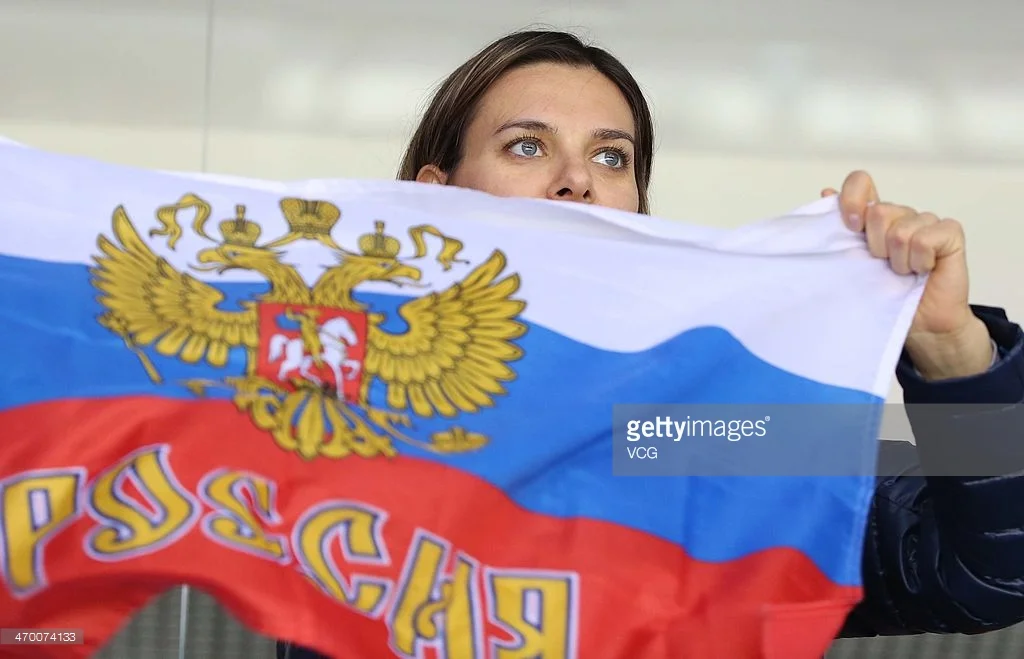 Yelena Isinbayeva with a Russian flag at a hockey game during the 2014 Winter Olympics in Sochi, Russia. The two-time Olympic pole vault champion calls the ban on Russian track and field athletes a human rights violation. (Getty Images)