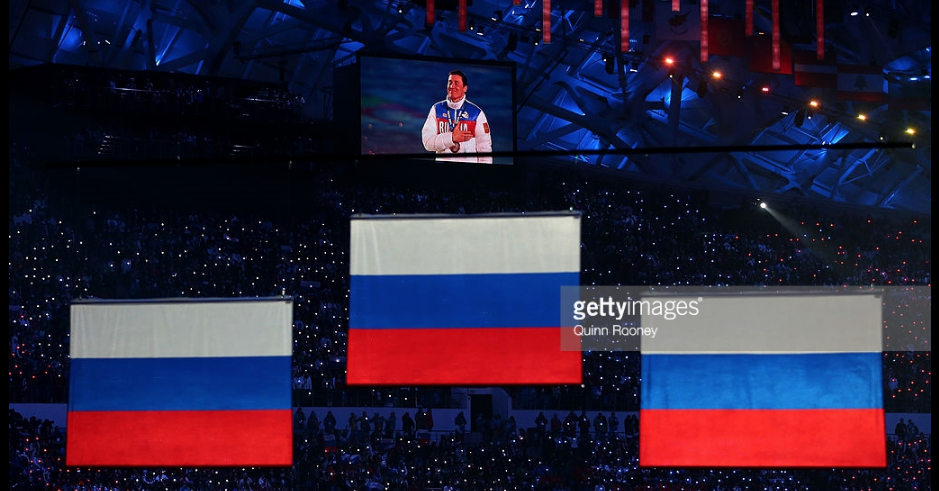 Gold medalist Alexander Legkov shown on the video screen as Russian flags are raised to mark its medal sweep in the 50-kilometer mass start cross-country ski race at the 2014 Olympics. Legkov and silver medalist Maksim Vylegzhanin have been disqualified from those Games for doping, among the cases that led IOC to say no Russian flags will fly officially at 2018 Winter Games.