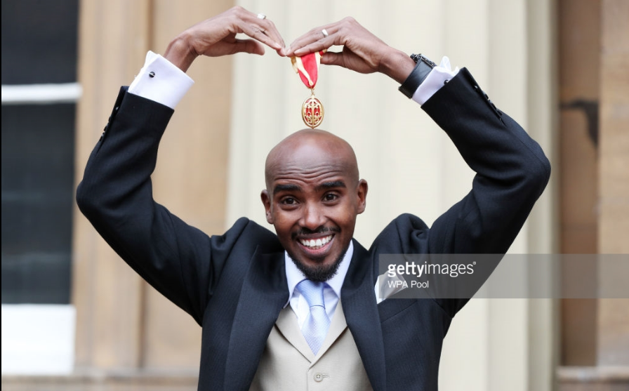 Sir Mo Farah strikes his "Mo-bot" pose after being invested as a knight by Queen Elizabeth in November.