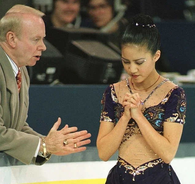Frank Carroll gives Michelle Kwan some final advice before her triumphant free skate at the 1996 World Championships. (Getty Images)