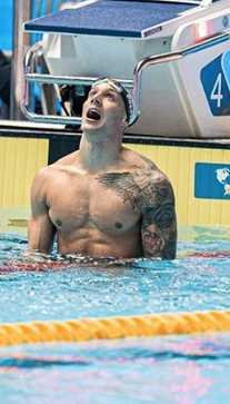 Caeleb Dressel looks at his world record time in 100 butterfly