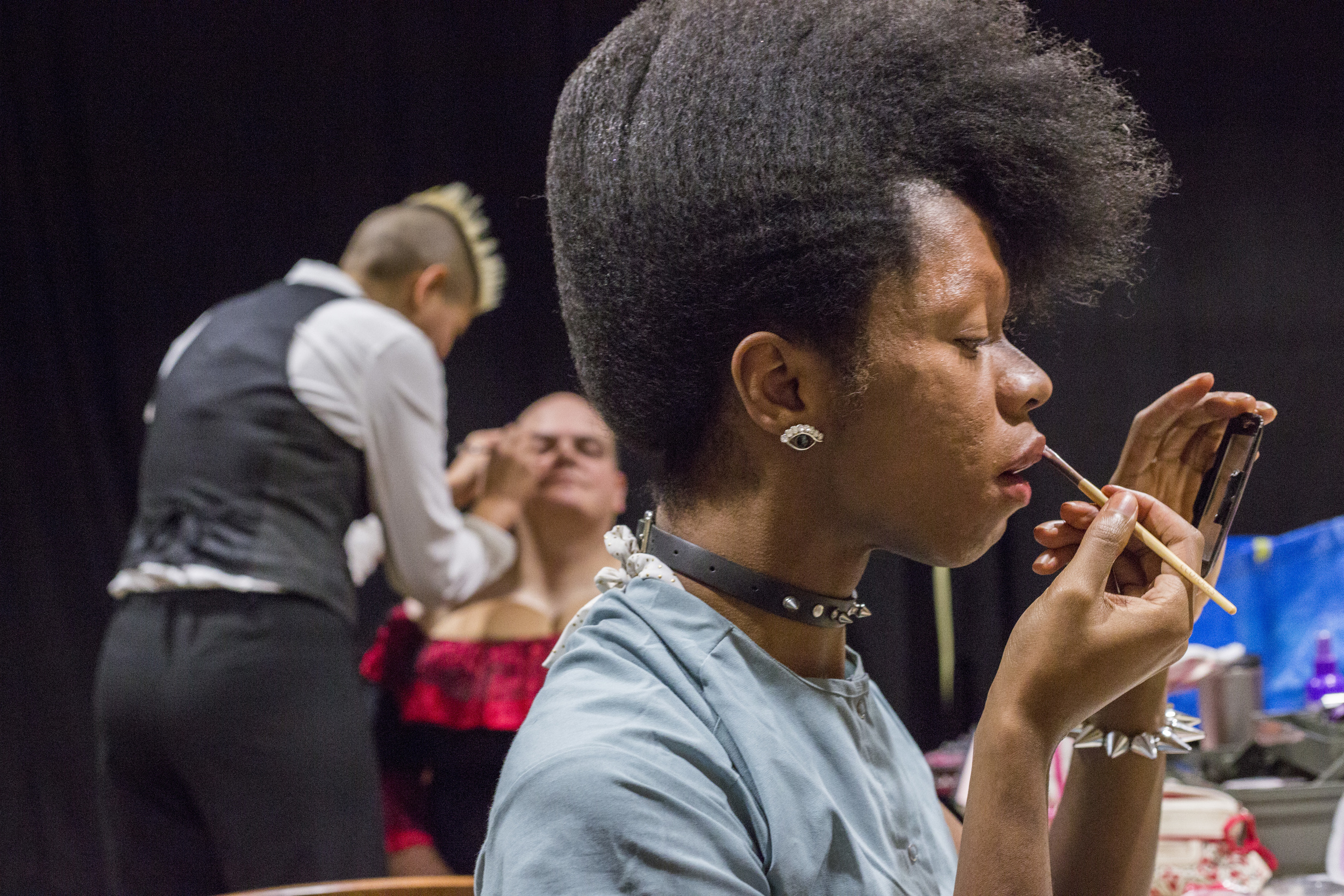  Pop "ShaVaughn" Peterson, front, of Athens, Ohio puts on lipstick while Ohio University English department instructor Megan Villegas, back left, does makeup for Delfin Bautista, back right, of Athens, Ohio in preparation for the drag show on January